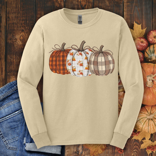 Sand long sleeve tee with 3 quilted pumpkins in plaid, floral, and striped patterns.