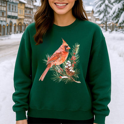 Green sweatshirt with a red cardinal on a snowy evergreen branch illustration, featuring a prominent crest and detailed feathers.