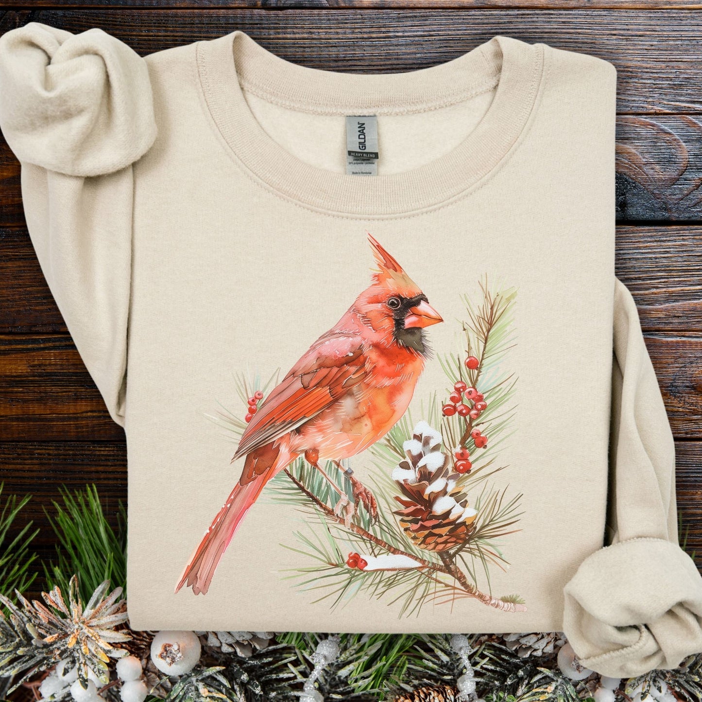 Sand sweatshirt with a red cardinal on a snowy evergreen branch design.