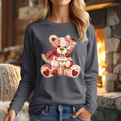 Woman in a gray long-sleeve tee with a red patchwork country teddy bear holding hot chocolate.