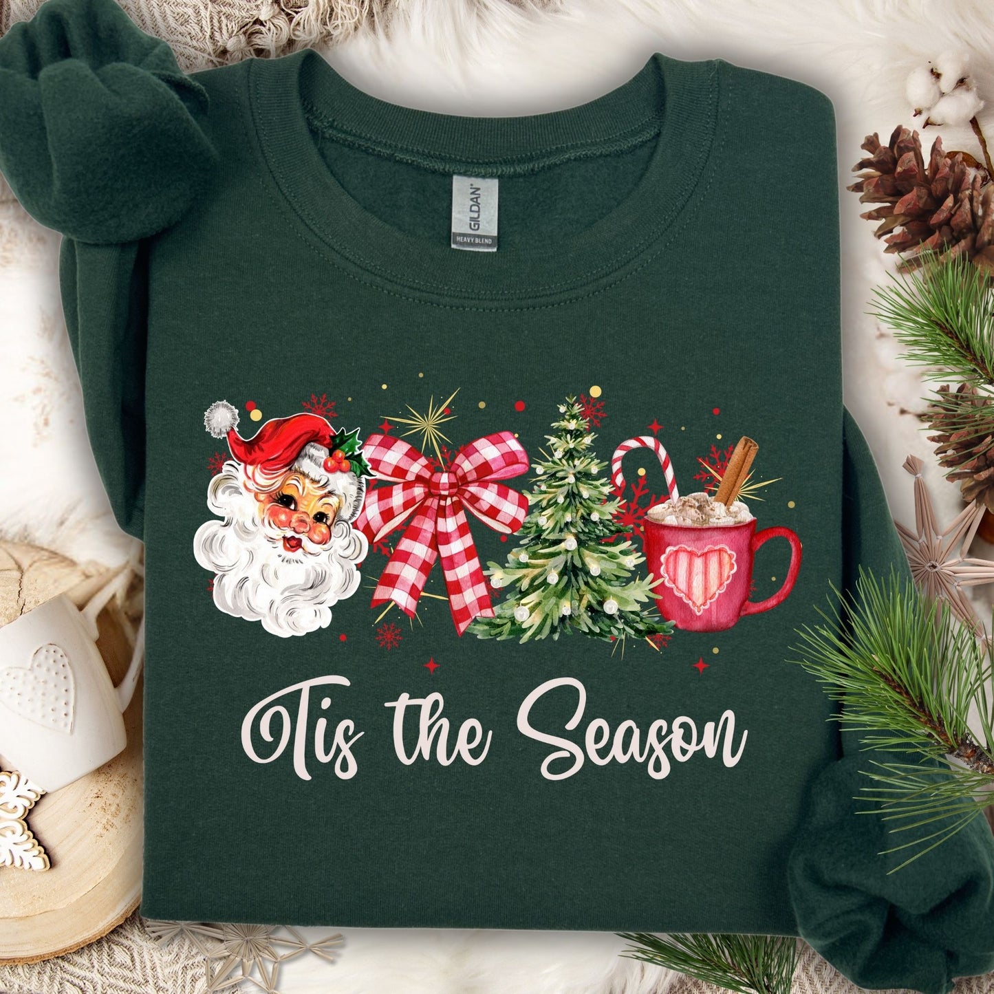 Forest green Gildan sweatshirt with retro Santa, plaid bow, Christmas tree, cocoa, and "Tis the Season" text.
