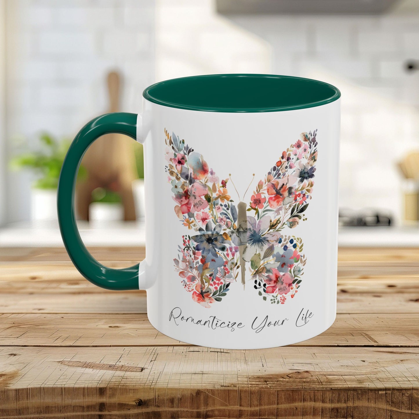White ceramic mug with a watercolor floral butterfly, "Romanticize Your Life" text, and a green interior/handle.