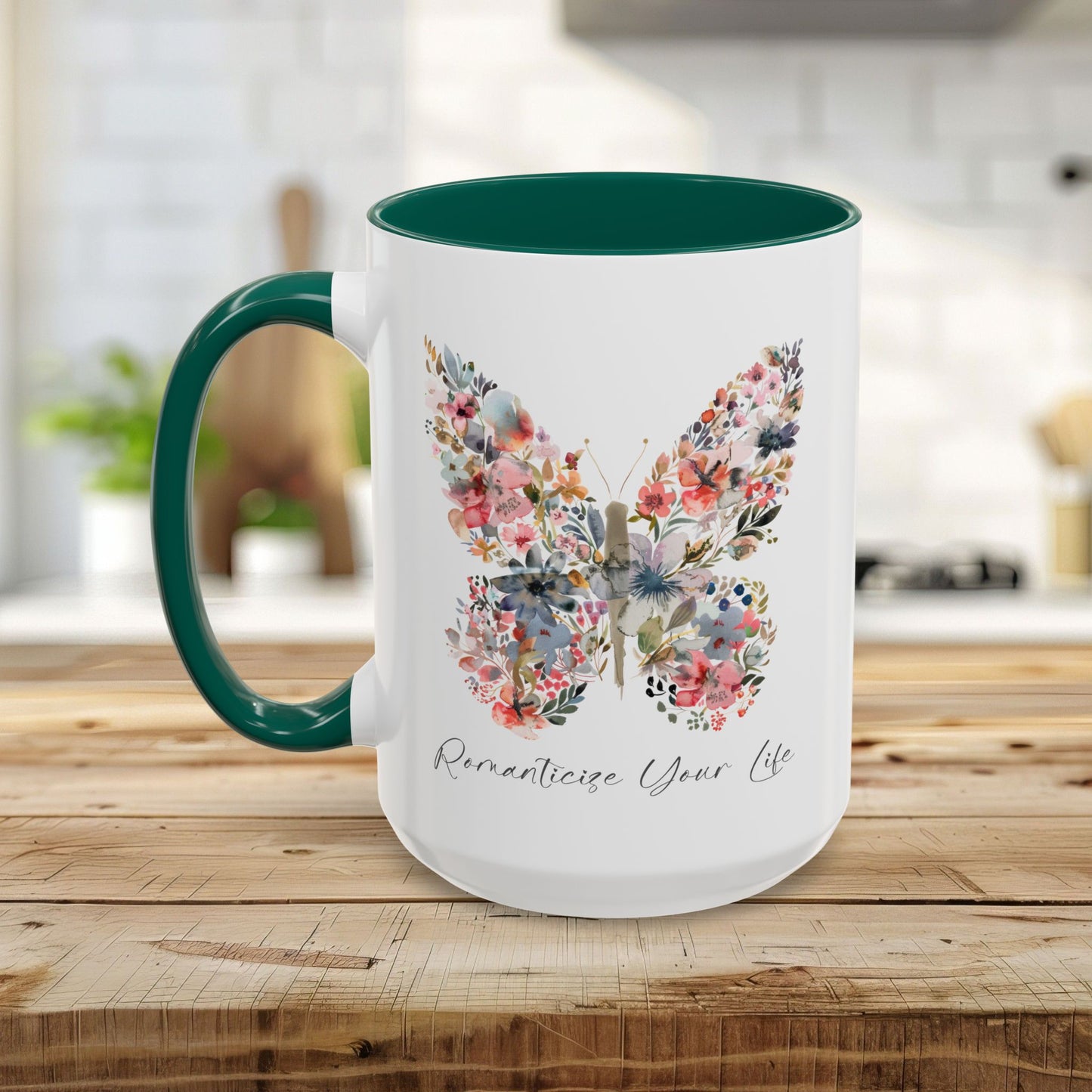 White ceramic mug with a watercolor floral butterfly, green handle, and "Romanticize Your Life" text.