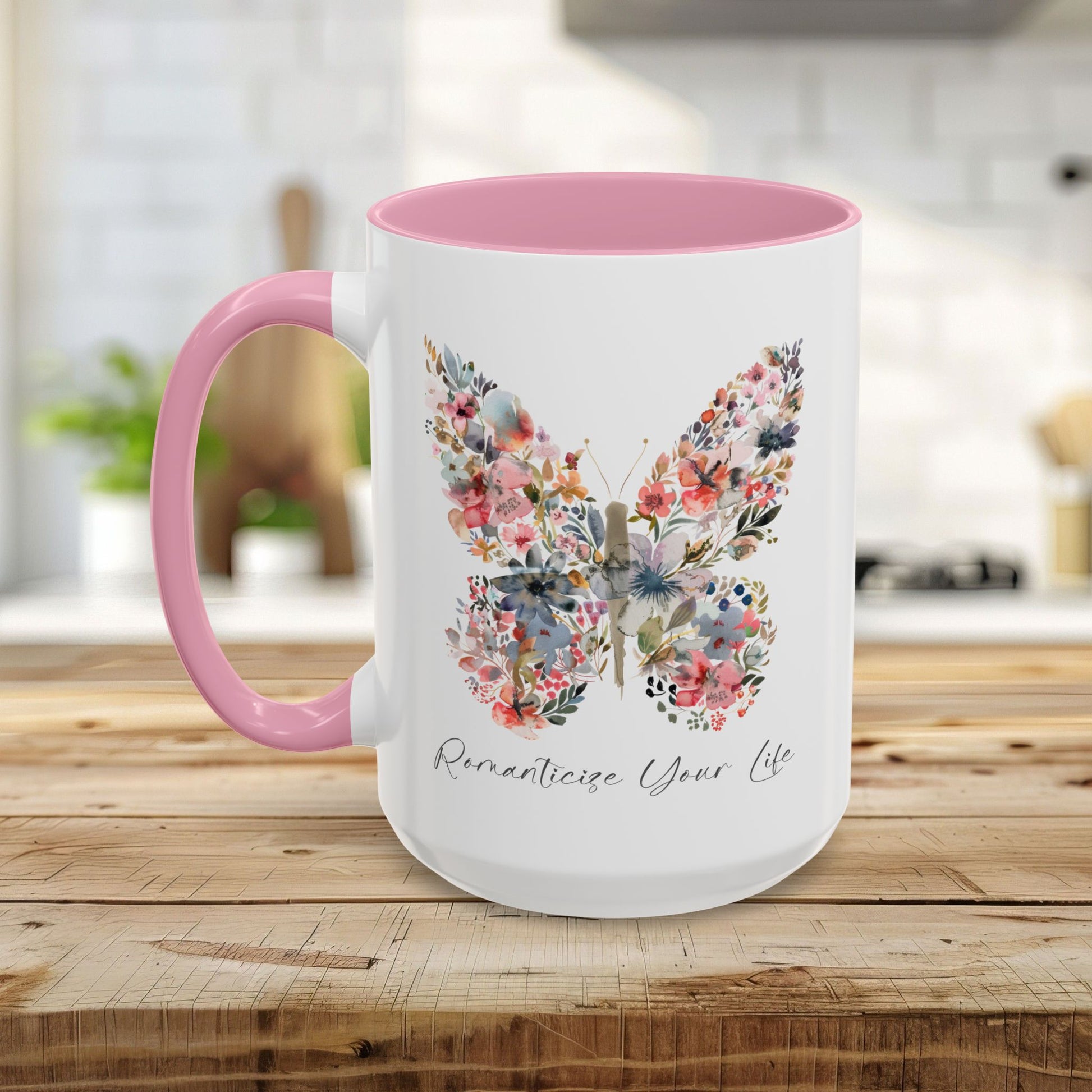White ceramic mug with pink handle and interior, featuring a watercolor floral butterfly and "Romanticize Your Life" text.