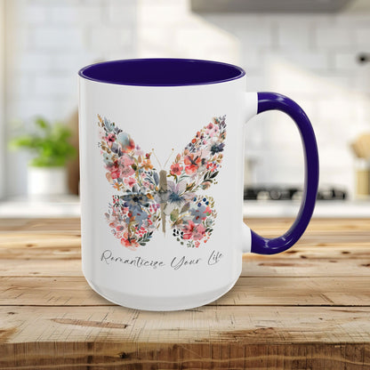 White 15oz ceramic mug with blue interior/handle and a watercolor floral butterfly design, "Romanticize Your Life" text.