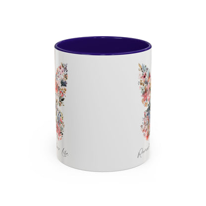 White ceramic mug with a watercolor butterfly design in pinks, blues, and greenery, featuring a purple interior.