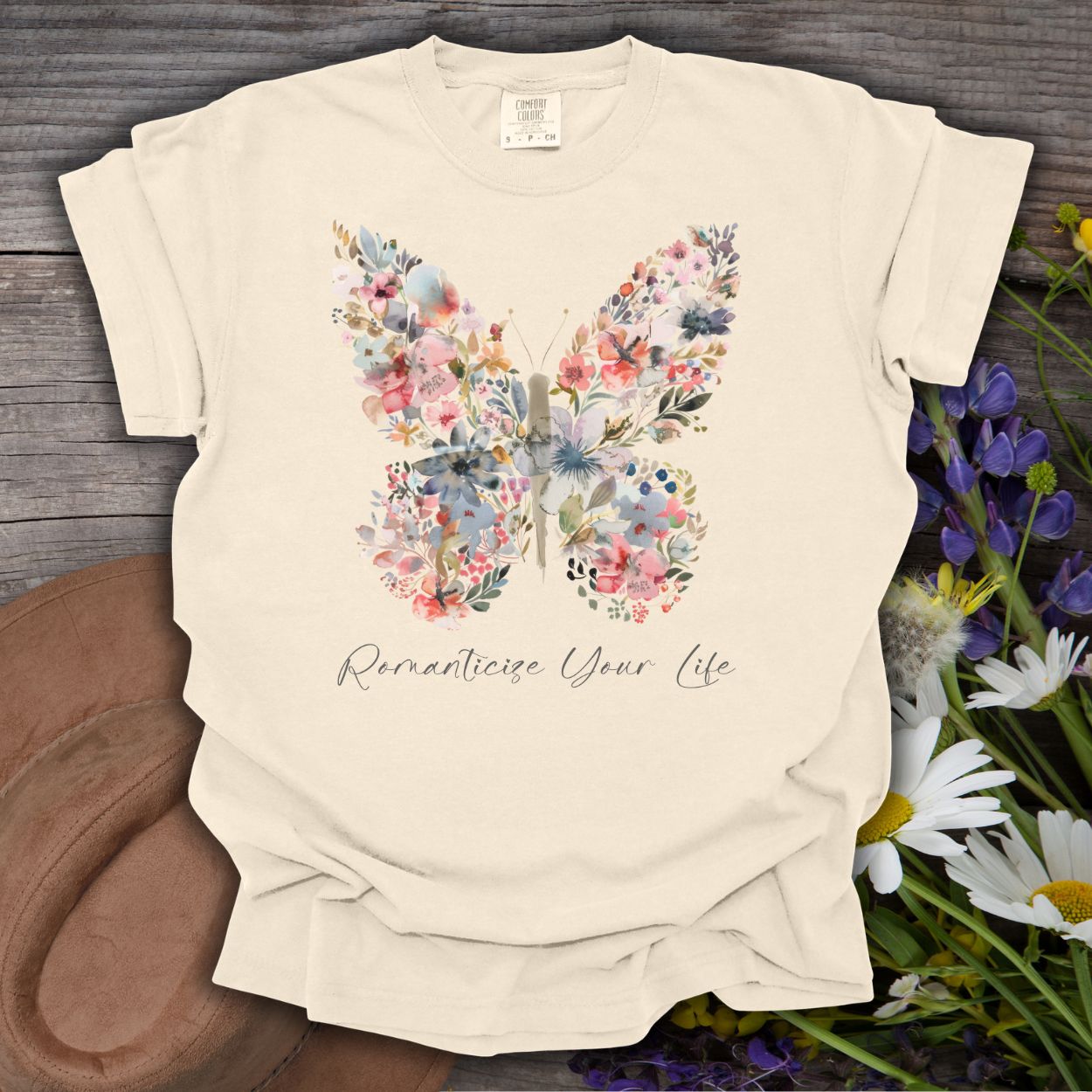 Ivory S-size cotton t-shirt with a watercolor floral butterfly and "Romanticize Your Life" text.