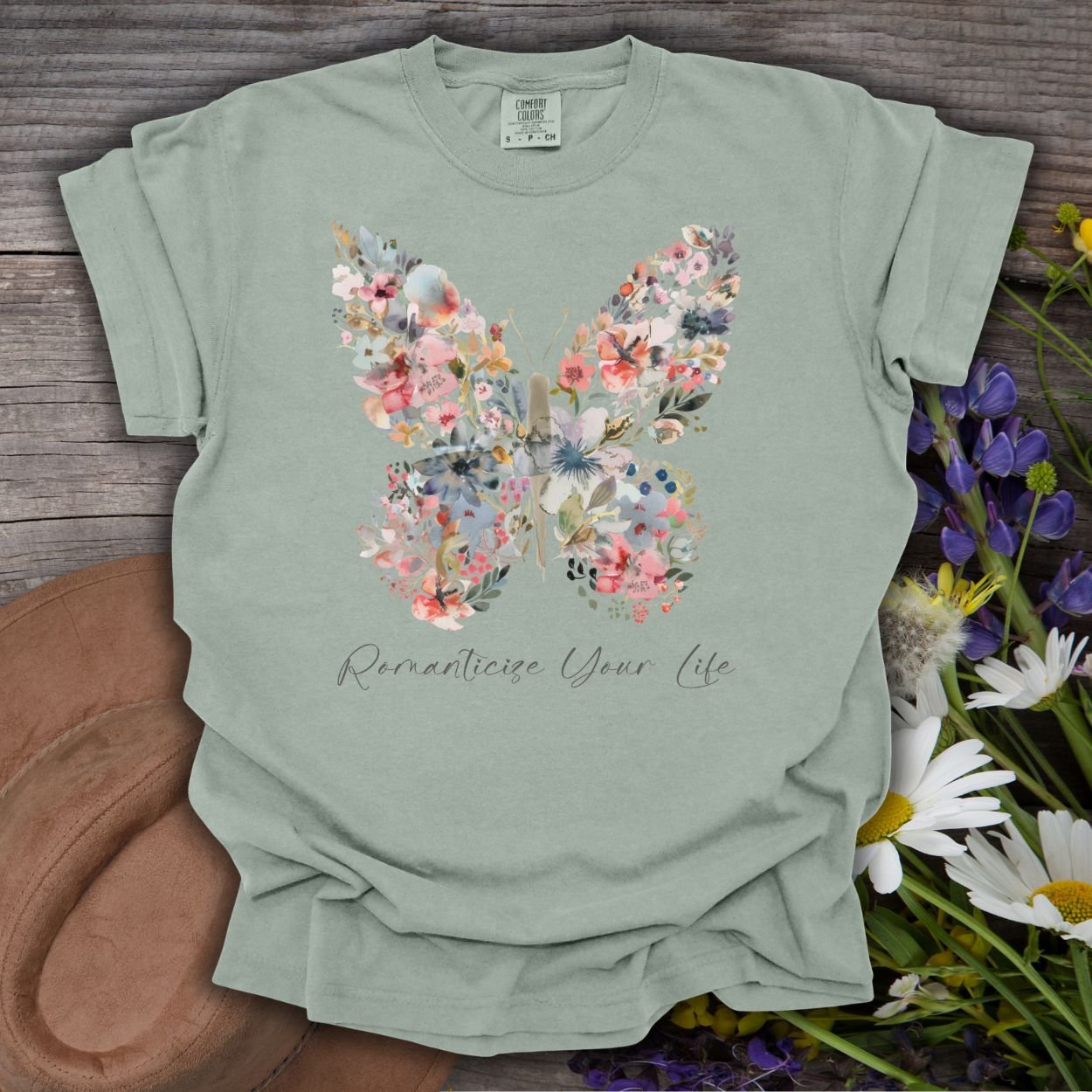 Bay green, relaxed-fit cotton t-shirt with a floral butterfly design and "Romanticize Your Life" text.