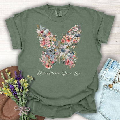 Moss green garment-dyed t-shirt with a floral butterfly design and "Romanticize Your Life" text.