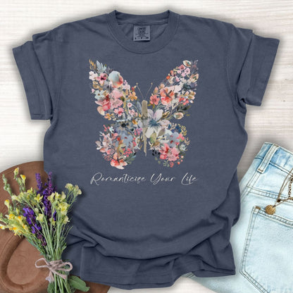 Denim blue garment-dyed cotton t-shirt with a floral butterfly design and "Romanticize Your Life" text.