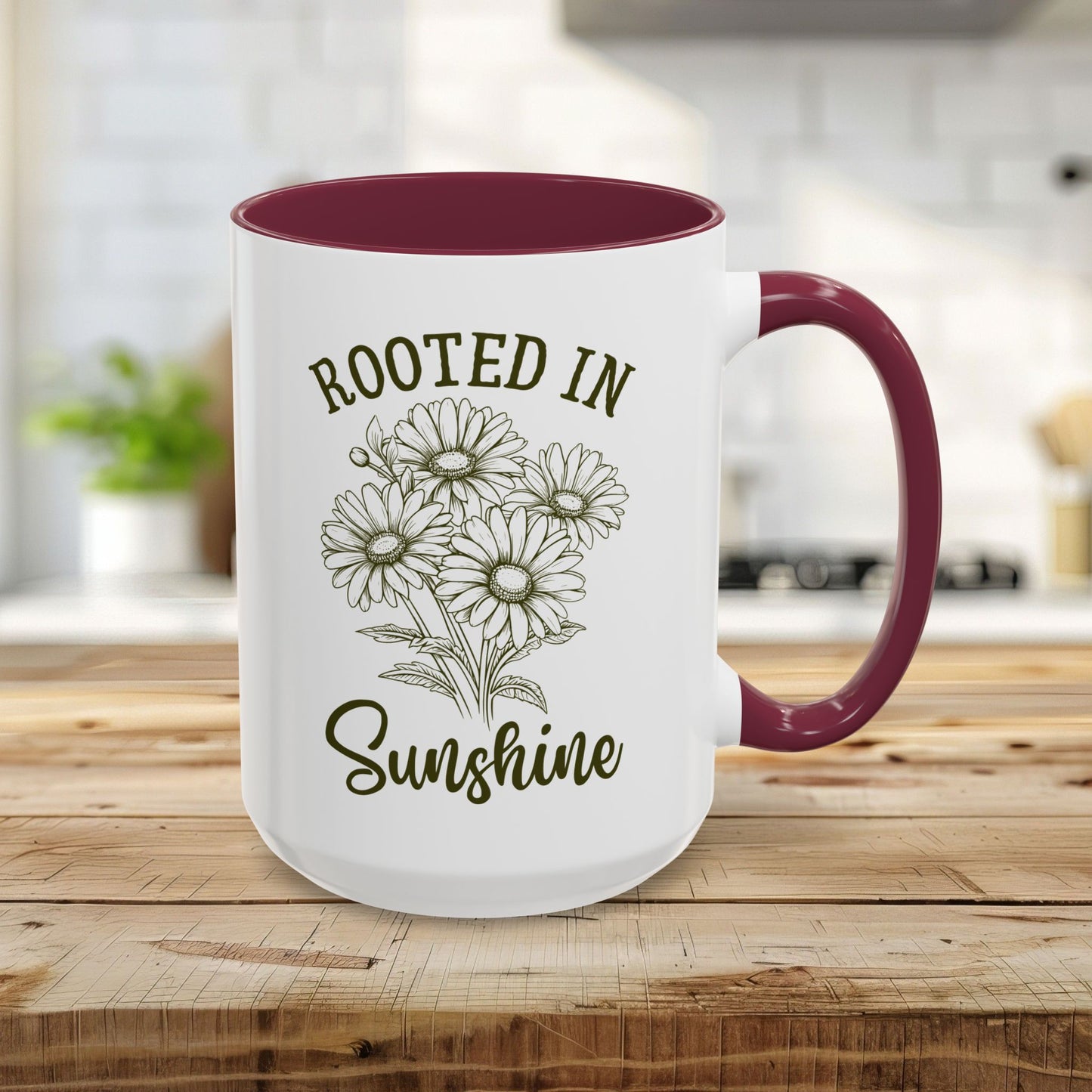 15oz glossy white ceramic mug with maroon interior/handle, "Rooted in Sunshine" text, and hand-drawn daisies.