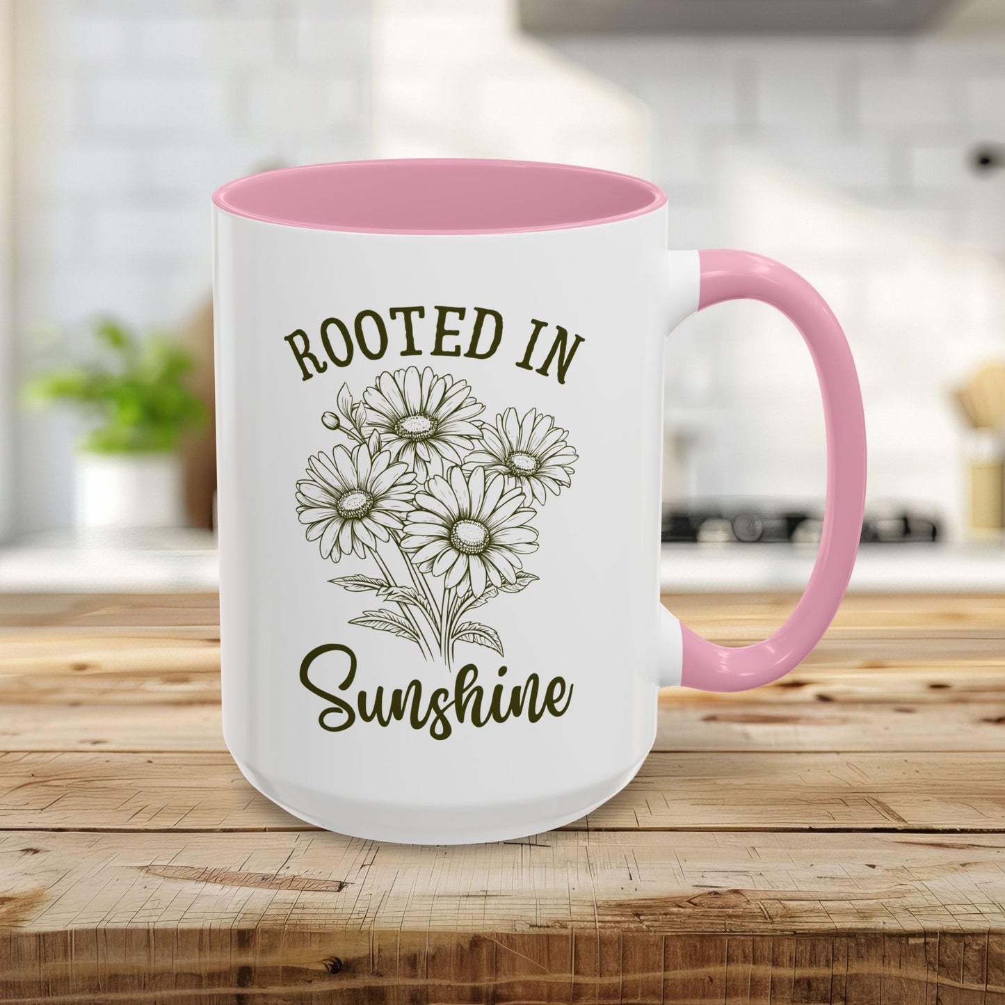 15oz white ceramic mug with pink interior/handle, "Rooted in Sunshine" text, and hand-drawn daisies.