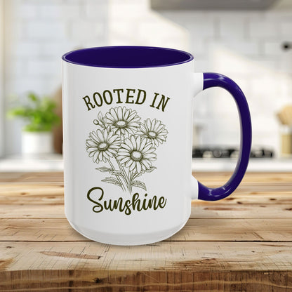 15oz white ceramic mug with blue interior/handle, "Rooted in Sunshine" text, and hand-drawn daisies.