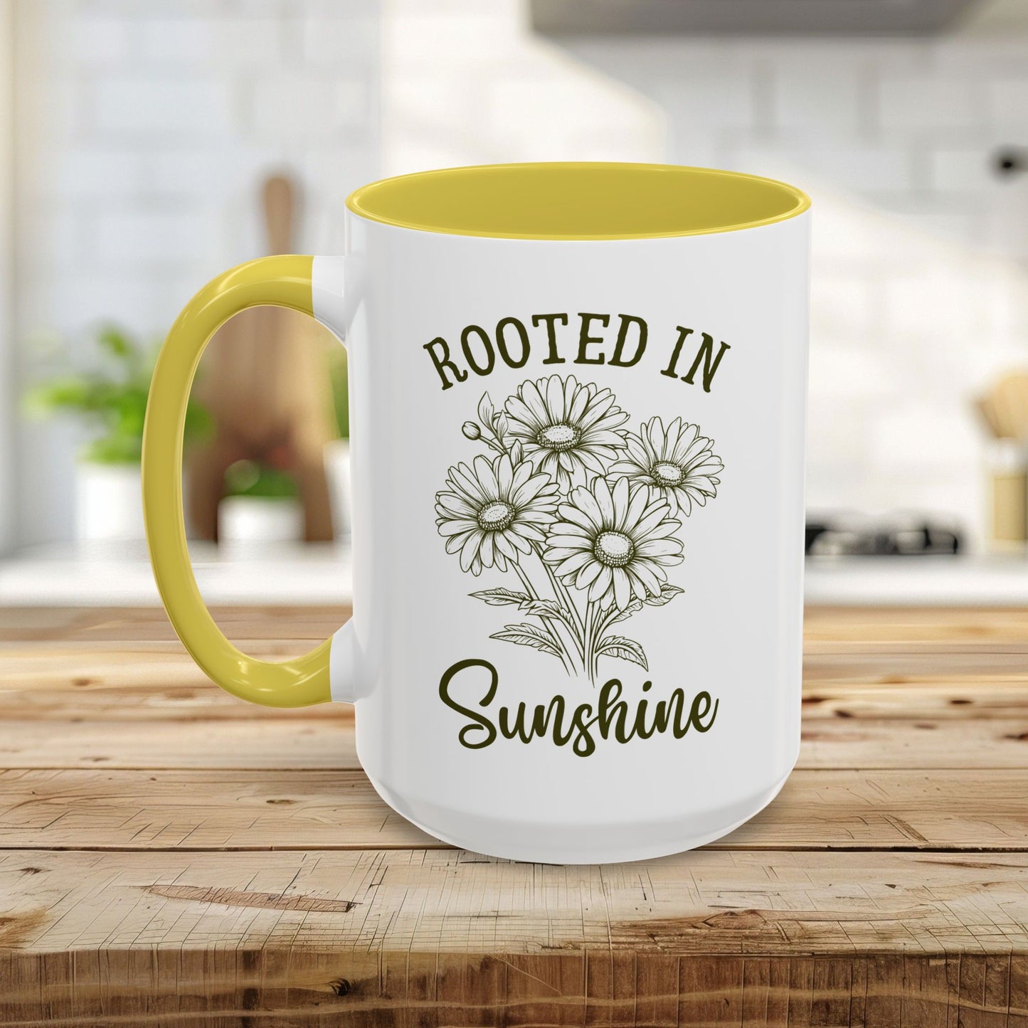 White ceramic mug with yellow interior and handle, featuring "Rooted in Sunshine" text and hand-drawn daisies.