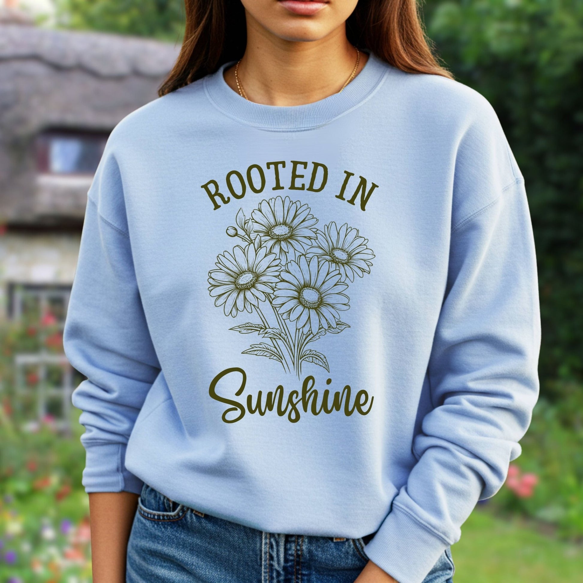 Light blue unisex sweatshirt with "Rooted in Sunshine" text and hand-drawn daisy bouquet.