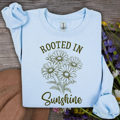 Light blue unisex sweatshirt with "Rooted in Sunshine" text and a hand-drawn daisy bouquet.