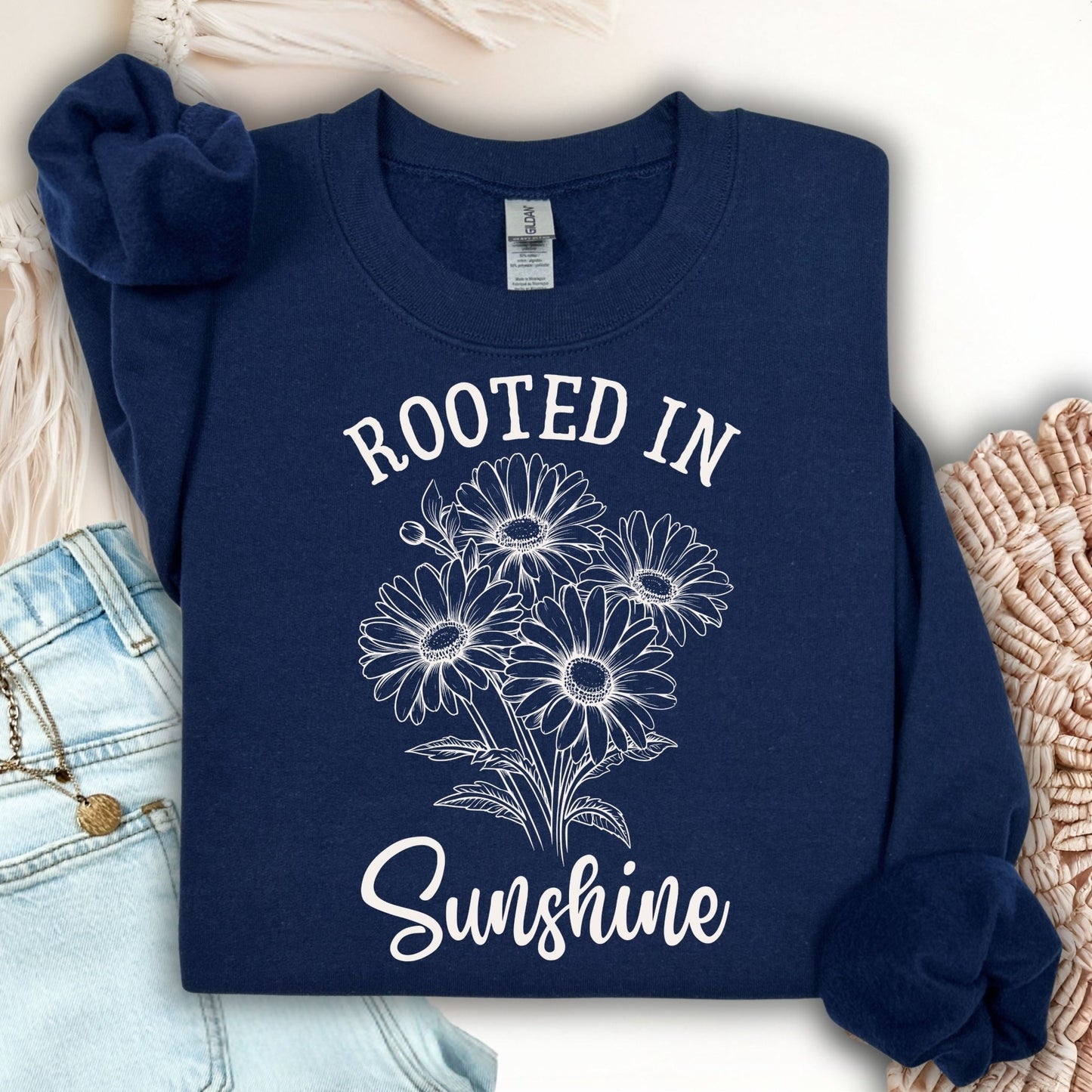 Navy unisex sweatshirt with "Rooted in Sunshine" and a hand-drawn daisy bouquet design.