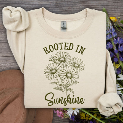 Sand unisex sweatshirt with "Rooted in Sunshine" text and hand-drawn daisy bouquet.