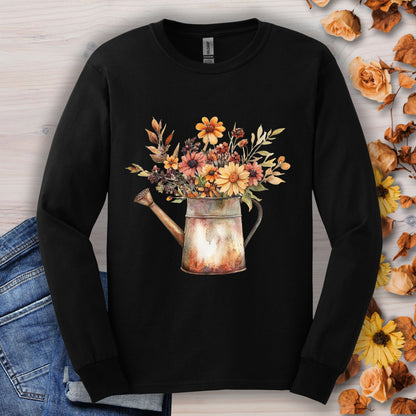 Black long sleeve tee with a watercolor watering can overflowing with autumn wildflowers.
