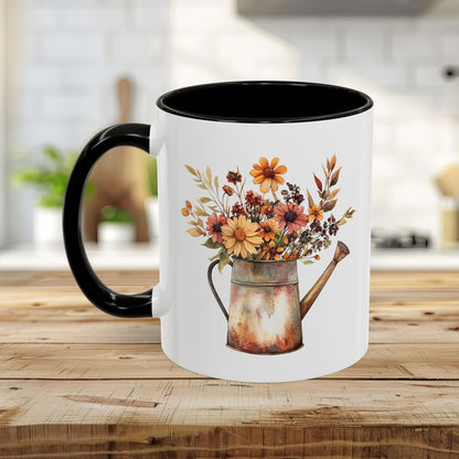 Ceramic mug with a rustic watercolor watering can overflowing with warm autumn florals, black handle and interior.