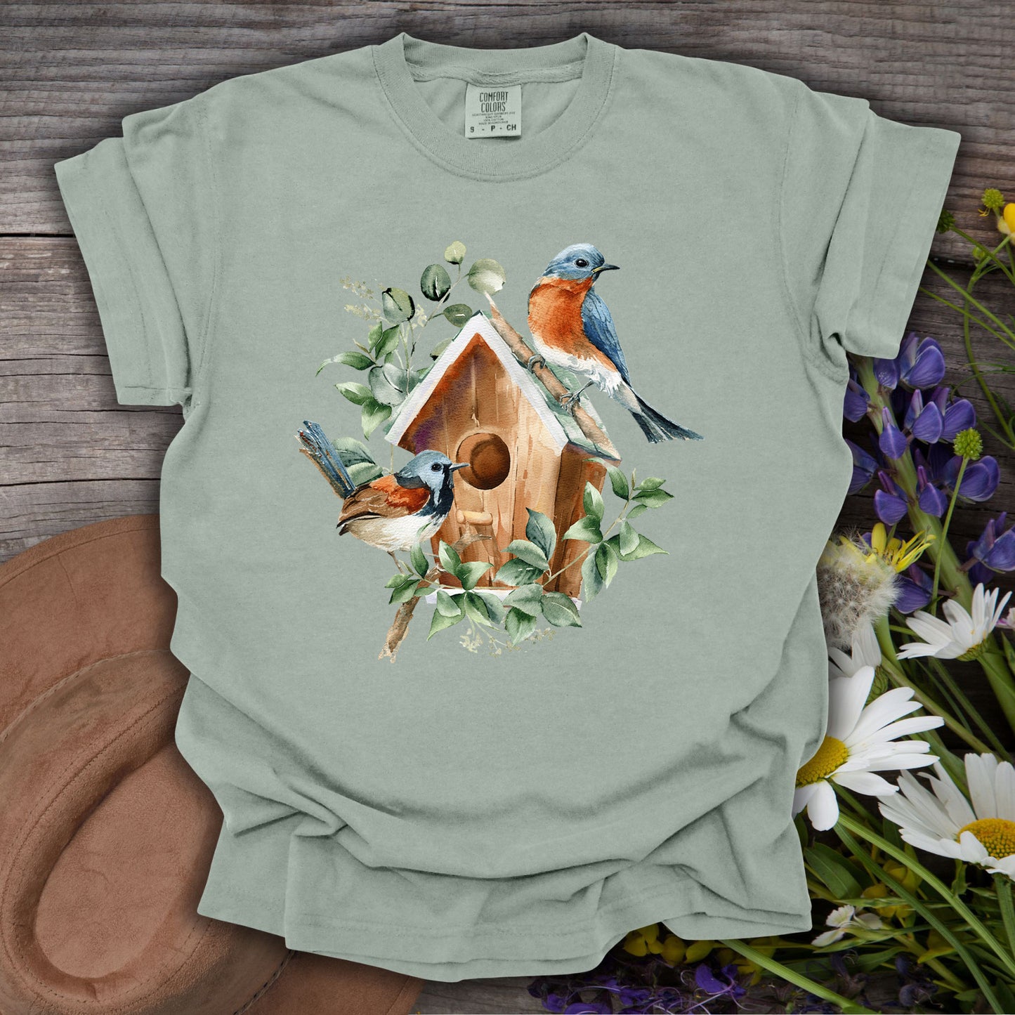 Bay S t-shirt with watercolor rustic birdhouse, two bluebirds, and botanical elements.