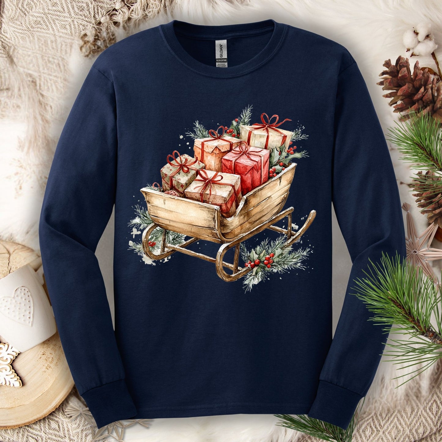 Navy long sleeve tee with a watercolor rustic Christmas sleigh brimming with gifts and greenery.