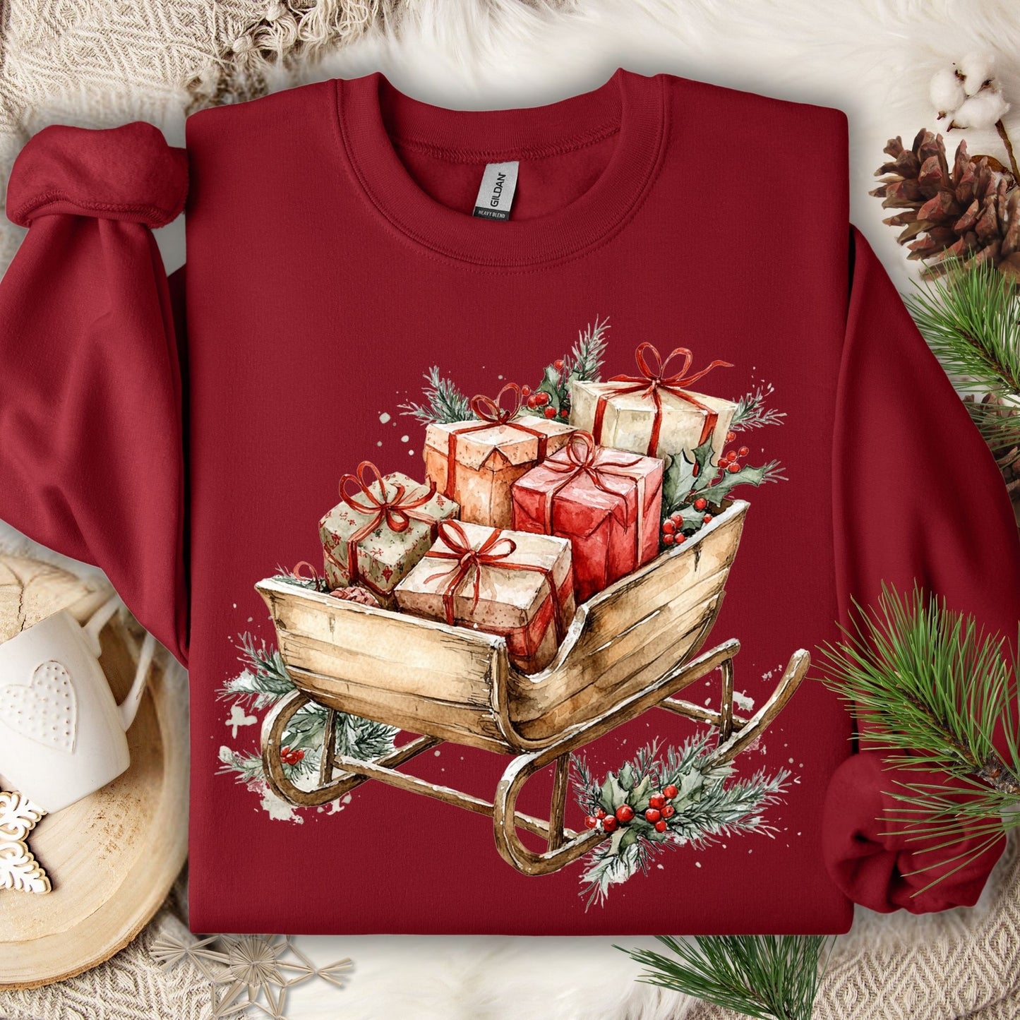 Cardinal Red Gildan fleece sweatshirt with a rustic watercolor sleigh overflowing with gifts and evergreens.