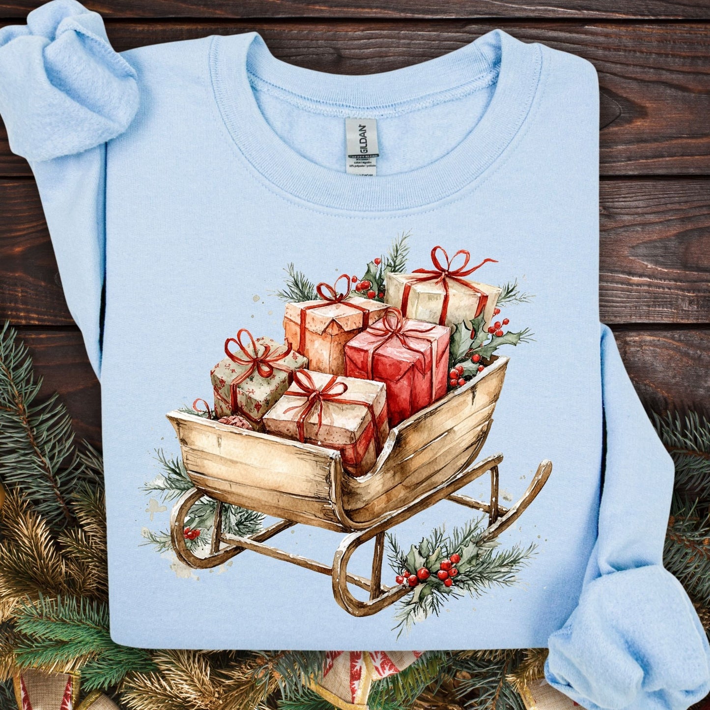 Light blue Gildan fleece sweatshirt with a rustic watercolor sleigh full of Christmas gifts and evergreens.