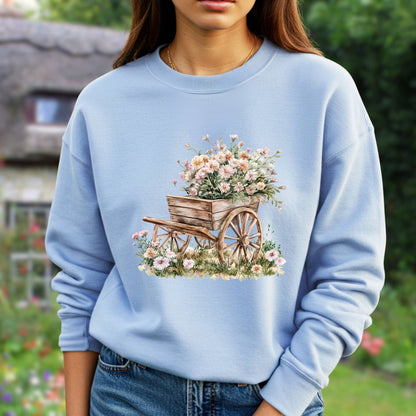 Light blue sweatshirt with a watercolor illustration of a rustic wooden wagon overflowing with pink carnations.