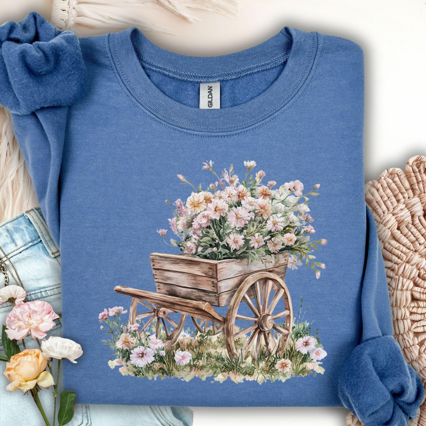 Indigo blue sweatshirt with a watercolor rustic wooden wagon overflowing with pink carnations.