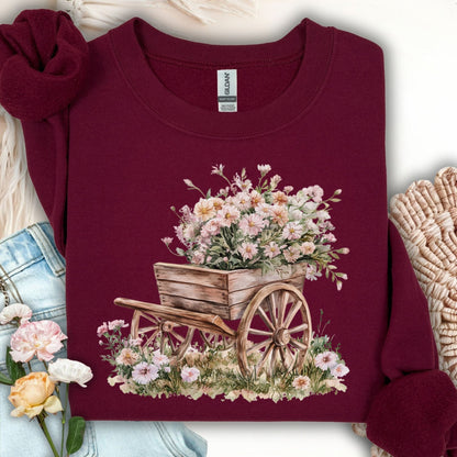 Maroon sweatshirt with a watercolor illustration of a rustic wooden wagon overflowing with pink and white carnations.
