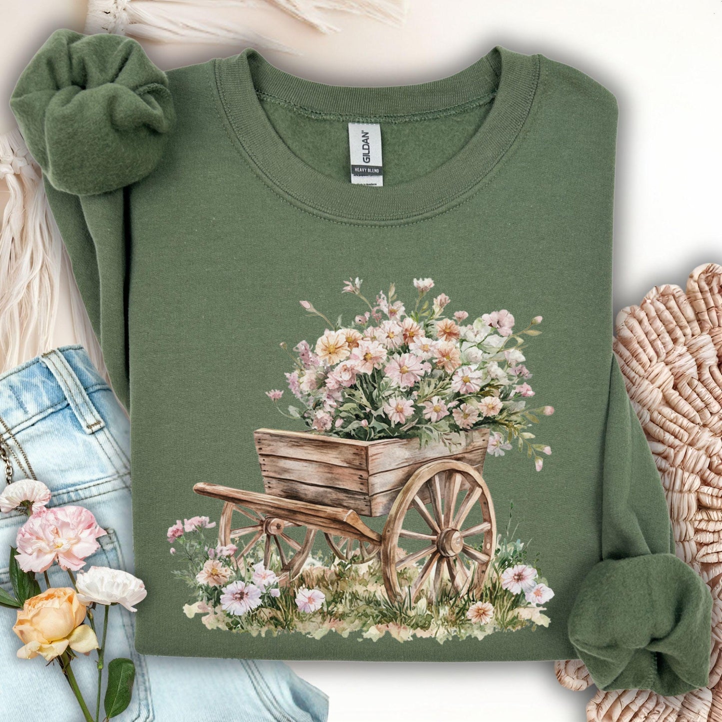 Military green sweatshirt with a rustic wooden wagon overflowing with pink and white carnations.