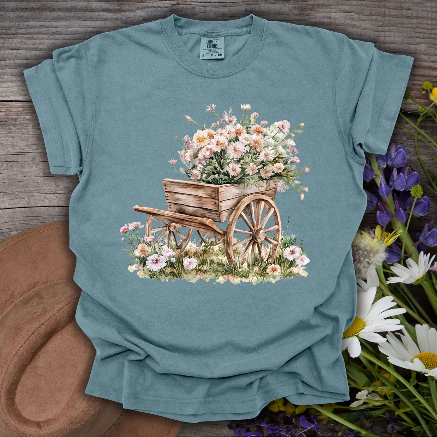 Ice Blue S-size t-shirt with a rustic wooden wagon overflowing with delicate pink and white flowers.
