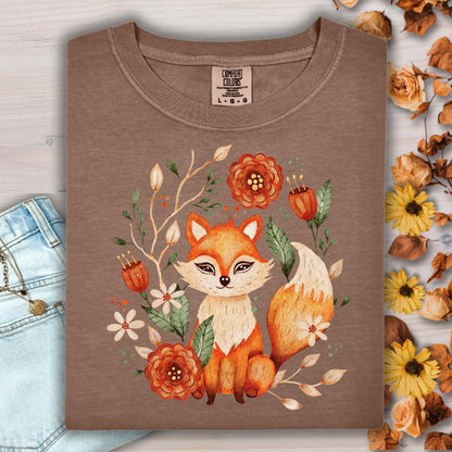Espresso tee with folk art fox and floral wreath design, next to jeans and autumn leaves.