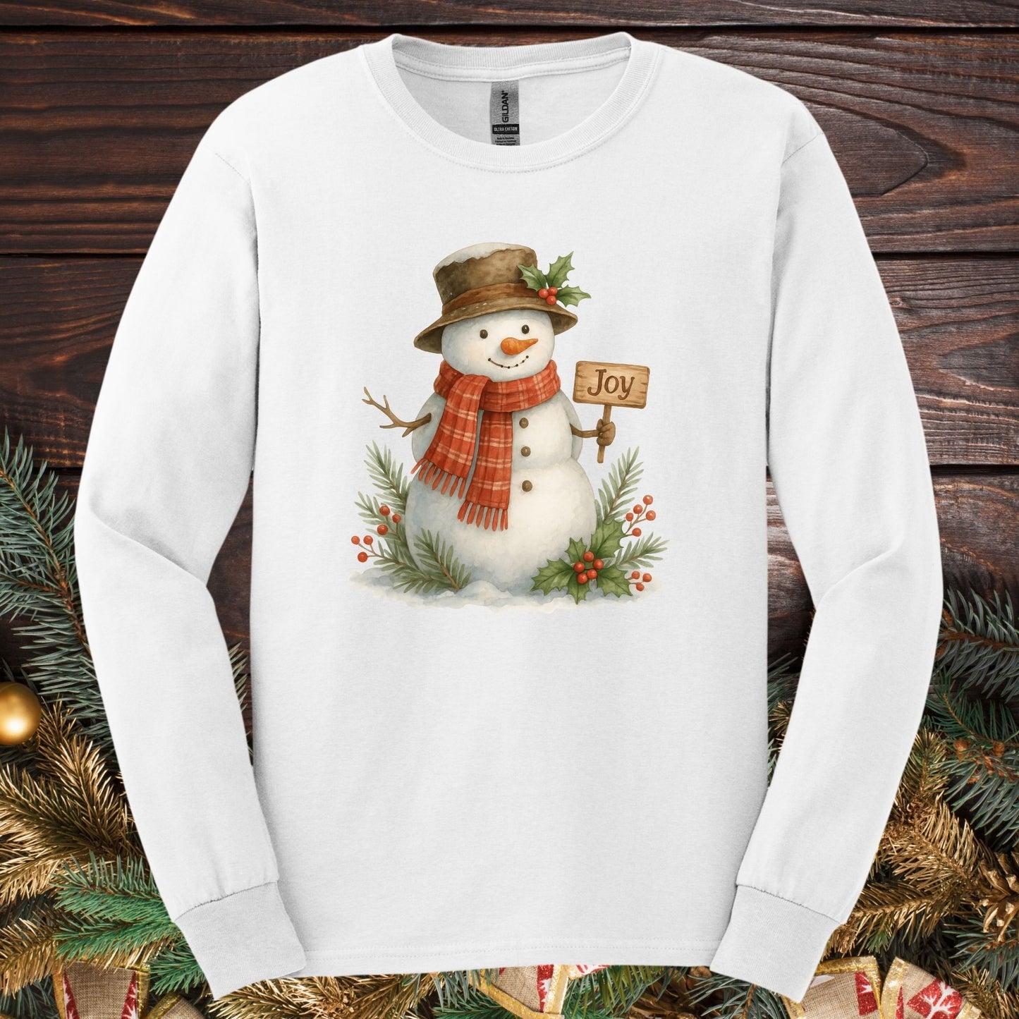White 100% cotton long sleeve tee with a watercolor snowman holding a "Joy" sign.