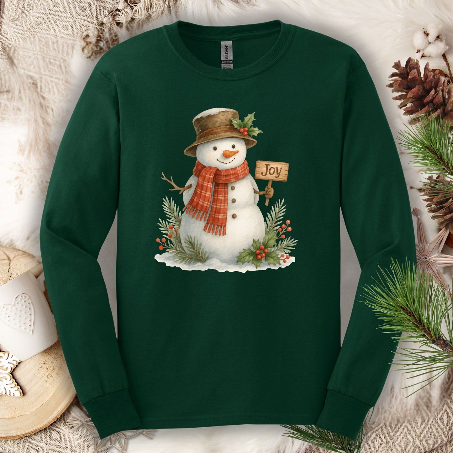 Forest Green long sleeve cotton tee with a watercolor snowman holding a "Joy" sign, holly, and pine.