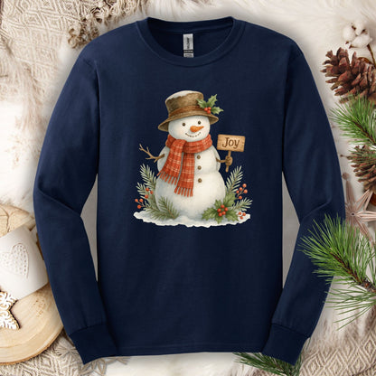Navy long sleeve tee with a watercolor snowman holding a "Joy" sign, holly, and snowy branches.