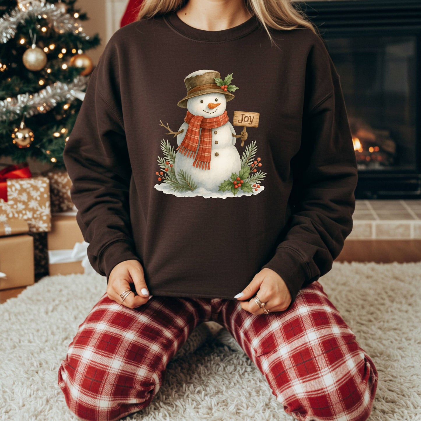 Brown Gildan 18000 sweatshirt with a watercolor snowman holding a "Joy" sign, surrounded by holly.