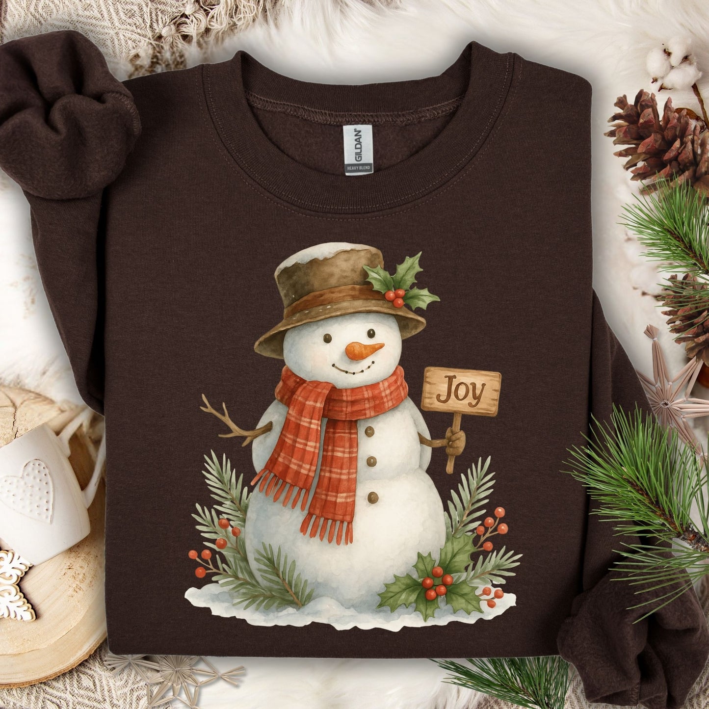 Dark Chocolate Gildan 18000 sweatshirt with a watercolor snowman holding a "Joy" sign, holly, and snowy branches.