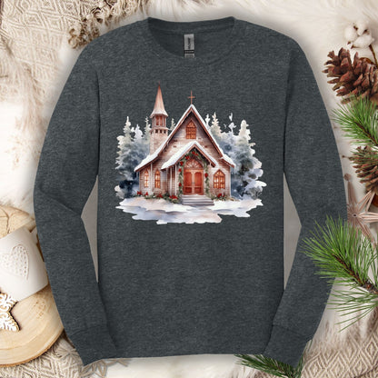 Dark Heather Gildan long sleeve tee with a rustic chapel, evergreens, snow, holly, and pine garland.