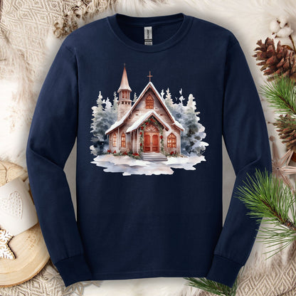 Navy long sleeve tee with a rustic, snow-dusted chapel, evergreens, holly, and pine garland.
