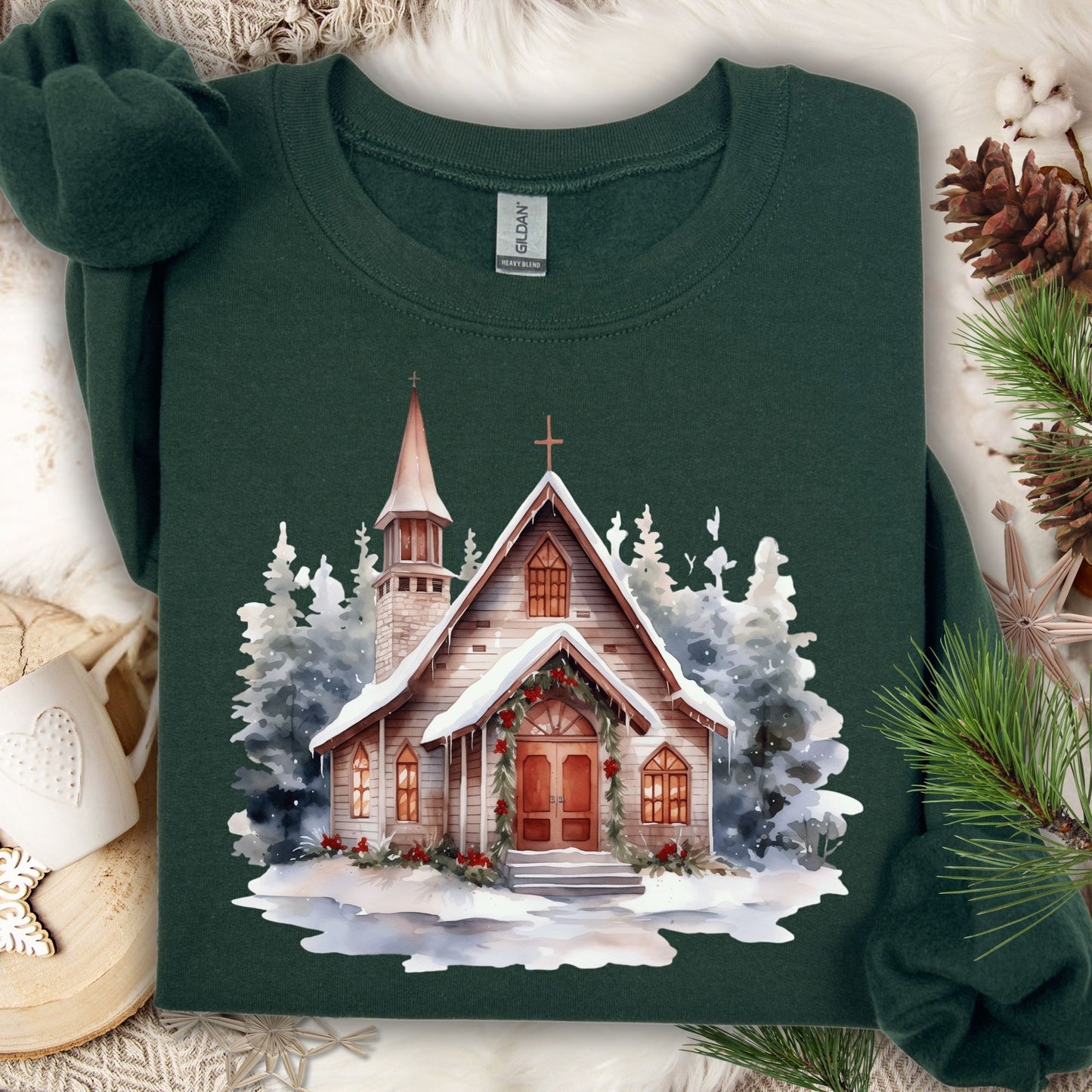 Forest Green Gildan sweatshirt with a watercolor rustic chapel in snow, adorned with Christmas greenery.