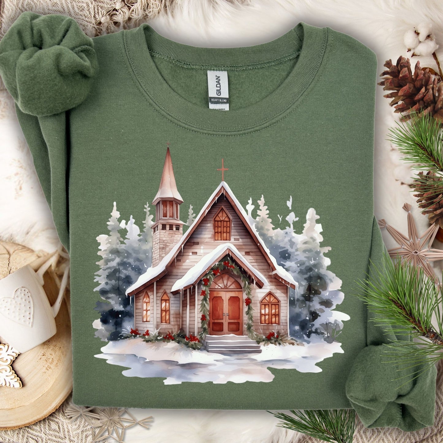 Military Green Gildan sweatshirt with watercolor rustic chapel in snow, festive greenery, and evergreens.