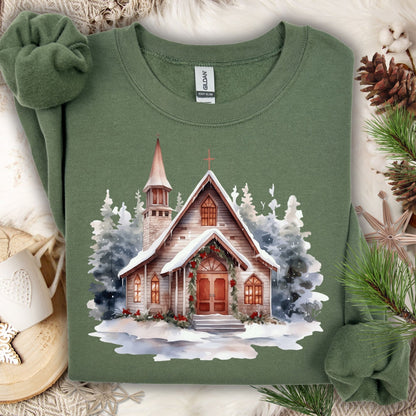Military Green Gildan sweatshirt with watercolor rustic chapel in snow, festive greenery, and evergreens.