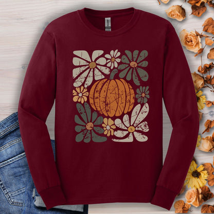 Maroon Gildan long sleeve tee with a rustic pumpkin and floral design, surrounded by dried flowers.