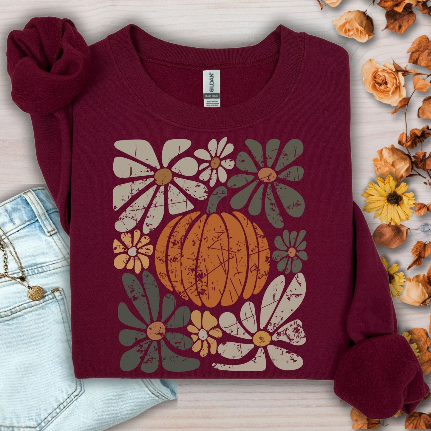 Maroon sweatshirt with a rustic pumpkin and floral design in autumn hues.