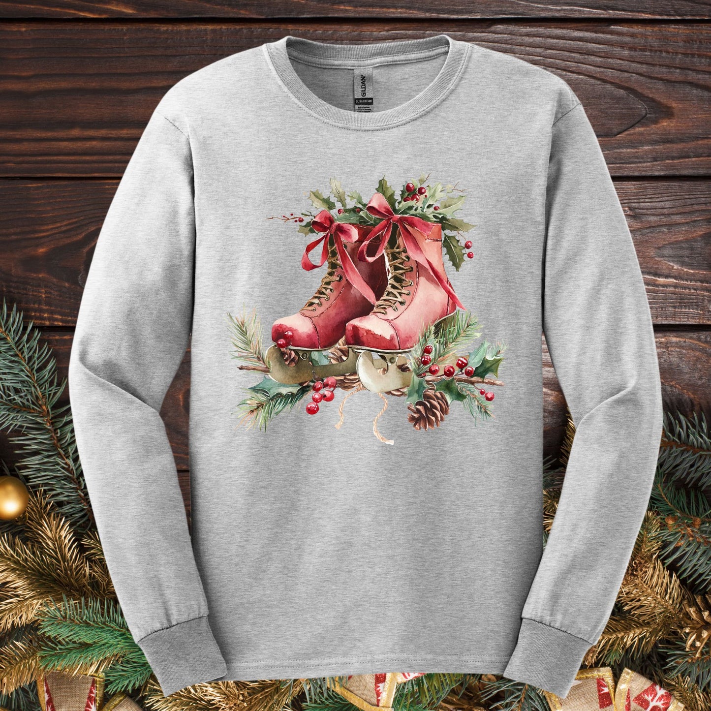 Ash long-sleeve tee with watercolor rustic red ice skates, holly, and evergreens.