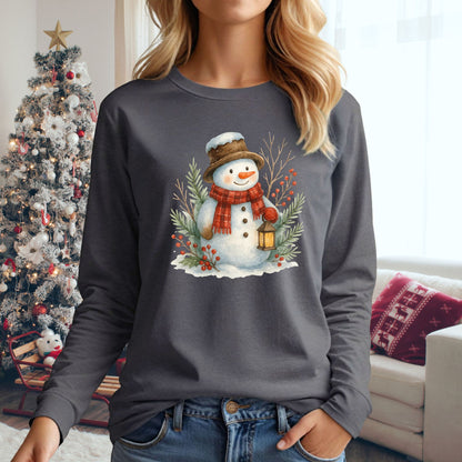 Charcoal long-sleeve tee with a watercolor snowman holding a lantern, surrounded by snowy branches.