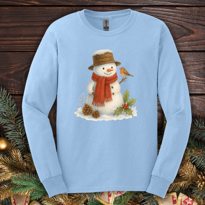 Light blue long sleeve tee with a rustic watercolor snowman, sparrow, holly, and pinecones.