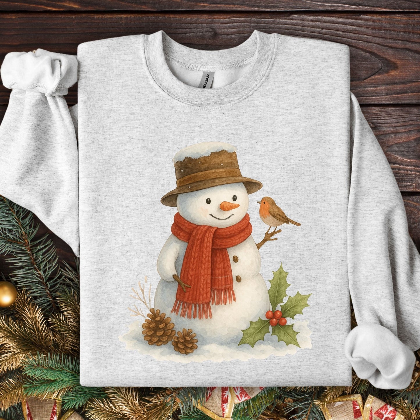 Ash gray Gildan 18000 sweatshirt with a watercolor snowman, sparrow, holly, and pinecones.